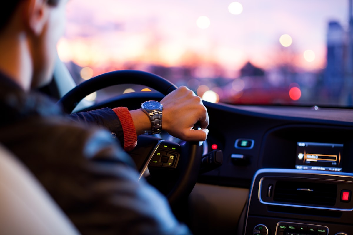 A driver behind the wheel of their car at dusk in the Houston area